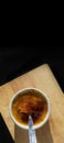 Top view homemade creme brulee in white ramekin  with sugar burn top up cracking with spoon on black background with copy space. Royalty Free Stock Photo
