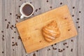 Top view of homemade croissant and hot black coffee on wooden ta