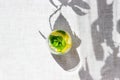 Top view of homemade lemonade with lemon, mint and ice cubes in glass on a grey background with hard leaves shadows. Royalty Free Stock Photo