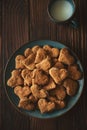 Top view on homemade wholegrain cookies with oatmeal, raisin, nuts, seeds and milk on brown rustic wooden background. Healthy