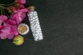 Top view of homeopathic pills bottles with wild fruit and pink flower on dark background. Natural Homeopathy Concept