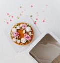 Top view of a honey cake with flowers on a box base next to windowed top