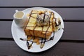 Top view of honey toast with ice cream, chocolate, whip cream and cereal topped.