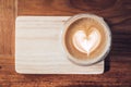 Top view of hot cappuccino coffee cup on wooden tray with heart Royalty Free Stock Photo