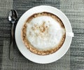 Top view of hot coffee cappuccino cup with spiral milk foam