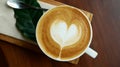 Top view of hot coffee cappuccino latte art heart shape in ceramic cup on wooden table background Royalty Free Stock Photo