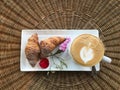 Top view of hot coffee with croissants decorate with flower on r