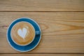 Top view of hot Coffee cup with art heart shape foam on wooden table background. Royalty Free Stock Photo