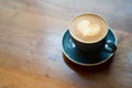 Top view of hot Coffee cup with a barista art heart shape foam on wooden table Royalty Free Stock Photo