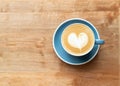 Top view of hot Coffee cup with a barista art heart shape foam on wooden table Royalty Free Stock Photo