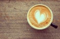 Top view, Hot coffee, heart shape with milk latte on top of black ceramic cup on wooden table in coffee shop in vintage tone, copy Royalty Free Stock Photo