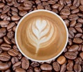 Top view of hot coffee latte art on coffee beans background. Royalty Free Stock Photo