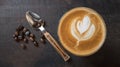 Top view of hot coffee latte art flower shape with spoon and coffee beans on wood table background Royalty Free Stock Photo