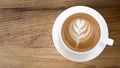 Top view of hot coffee latte art on wooden table background