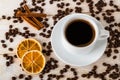 Top view of hot coffee in white elegant cup with saucer on a background of coffe beans over a white wooden table. Coffee with Royalty Free Stock Photo