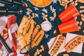 top view of hot dogs, plastic cups, peanuts, beer bottles, baseball ball and glove with bat Royalty Free Stock Photo