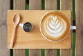 Top view hot latte coffee with hearts or flower pattern and syrup on wooden table Royalty Free Stock Photo
