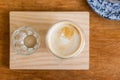 Top view of hot latte in a glass cup with a glass of water on wooden plate Royalty Free Stock Photo