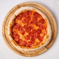 Top view of hot pizza on a wooden stand. Royalty Free Stock Photo