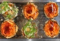 Top view of a hot plate with six Japanese okonomiyaki omelets brushed over with oyster sauce and chopped scallions. Royalty Free Stock Photo