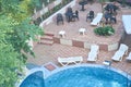 Top view of the hotel territory with round outdoor swimming pool with blue mosaic ceramic tiles, white plastic sun Royalty Free Stock Photo