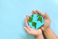 Top view of human hand holding planet earth model with green leaves. World earth day, save the environment, environmental Royalty Free Stock Photo