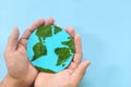 Top view of human hand holding planet earth model with green leaves. World earth day, save the environment, environmental Royalty Free Stock Photo