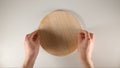 TOP VIEW: Human hands puts a round cutting board on a white table