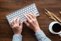 Top view of human hands typing on keyboard, wood desk Royalty Free Stock Photo