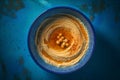 Top view of hummus in blue ceramic bowl. Generate ai Royalty Free Stock Photo