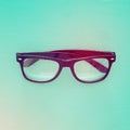 Top view image of black optical glasses over mint wooden background.
