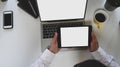 Top view image of business man holding a white blank screen tablet at the modern working desk. Royalty Free Stock Photo