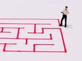 Top view image a businessman navigating through a maze.