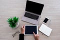 Top view image of businesswoman point at the tablet screen  on the wooden desk with other office gadgets Royalty Free Stock Photo