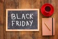 Top view image of chalkboard with the text black friday next to cup of coffee and notebook Royalty Free Stock Photo