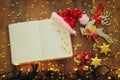Top view image of christmas festive decorations next to empty open notebook on old wooden background. Ready for adding text or moc Royalty Free Stock Photo