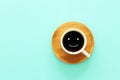 Top view image of coffe cup with happy face on wooden mint background. Flat lay Royalty Free Stock Photo