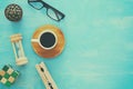 Top view image of cup of coffee, glasses, hourglass on wooden table.