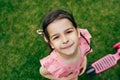 Top view image of cute child smiling and looking directly to the camera in the city park. Beautiful little girl playing and having Royalty Free Stock Photo