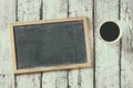 Top view image of empty blackboard next to cup of coffee , over wooden table Royalty Free Stock Photo