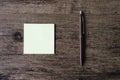 Top view image of empty sticky note paper and pen on the wooden