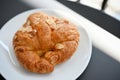 Top view image, Fresh French almond croissant on a white plate Royalty Free Stock Photo