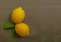 Top view image, Fresh yellow ripe lemon fruits and green leaf on brown wooden table