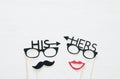 Top view image of funny photo booth props with text: HIS, HERS for party or wedding over white background.