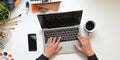 Top view image of graphic designer`s hands typing on black blank screen computer laptop that putting on the white working table. Royalty Free Stock Photo