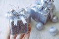 Top view image of a hand holding golden present boxes and Christmas decorations on white carpet Royalty Free Stock Photo