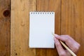 Top view image of a hand holding a pen and going to write on a blank white notebook Royalty Free Stock Photo