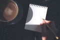 Top view image of a hand holding a pen and writing on a blank white notebook Royalty Free Stock Photo