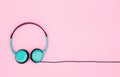 Top view image of headphones and earphones on pink pastel background. Retro style, minimalism. Flat lay