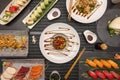 Top view image of Japanese sushi dishes with nigiri, red tuna tataki, uramaki roll, bao bread, salmon sashimi, red tuna, Royalty Free Stock Photo